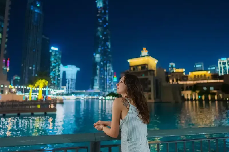 a woman standing in front of burj khalifa and Dubai fountain